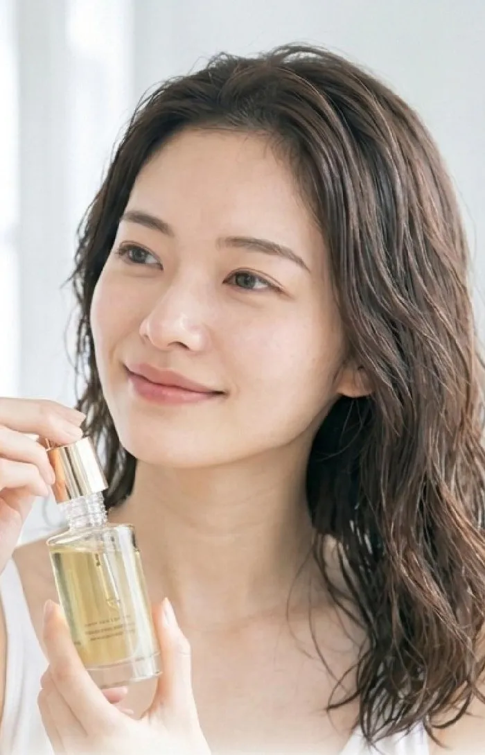 ヘアオイルを手に取る女性